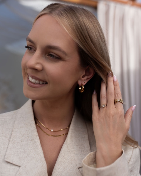 Warstwowy naszyjnik w odcieniu złota, łączący subtelną perłę z minimalistycznym łańcuszkiem