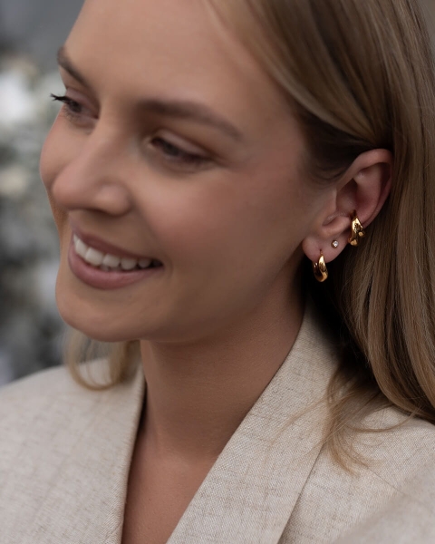 Złote hoops z dynamiczną, fantazyjnie wygiętą konstrukcją